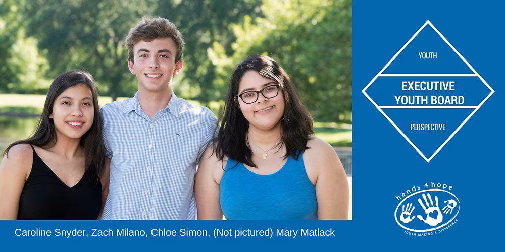 Three young people posing for a photo in a park