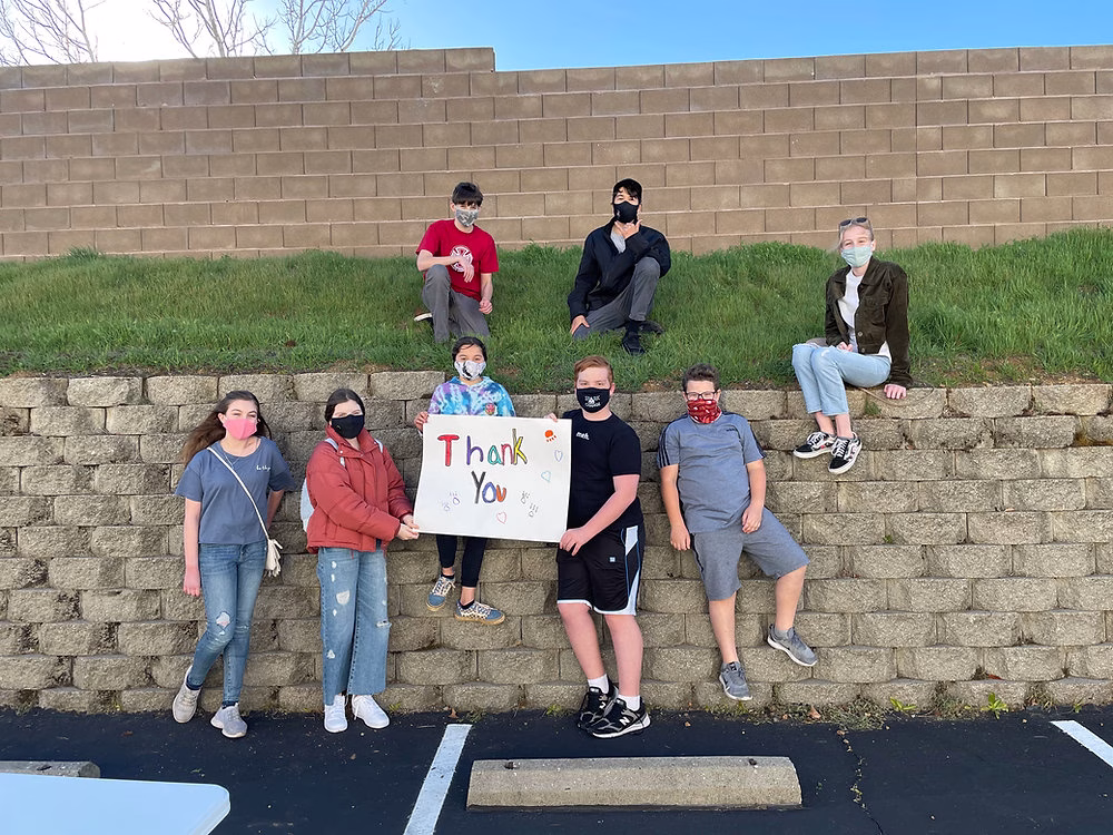 A group of children posing for a photo while holding a sign that says 'Thank You'