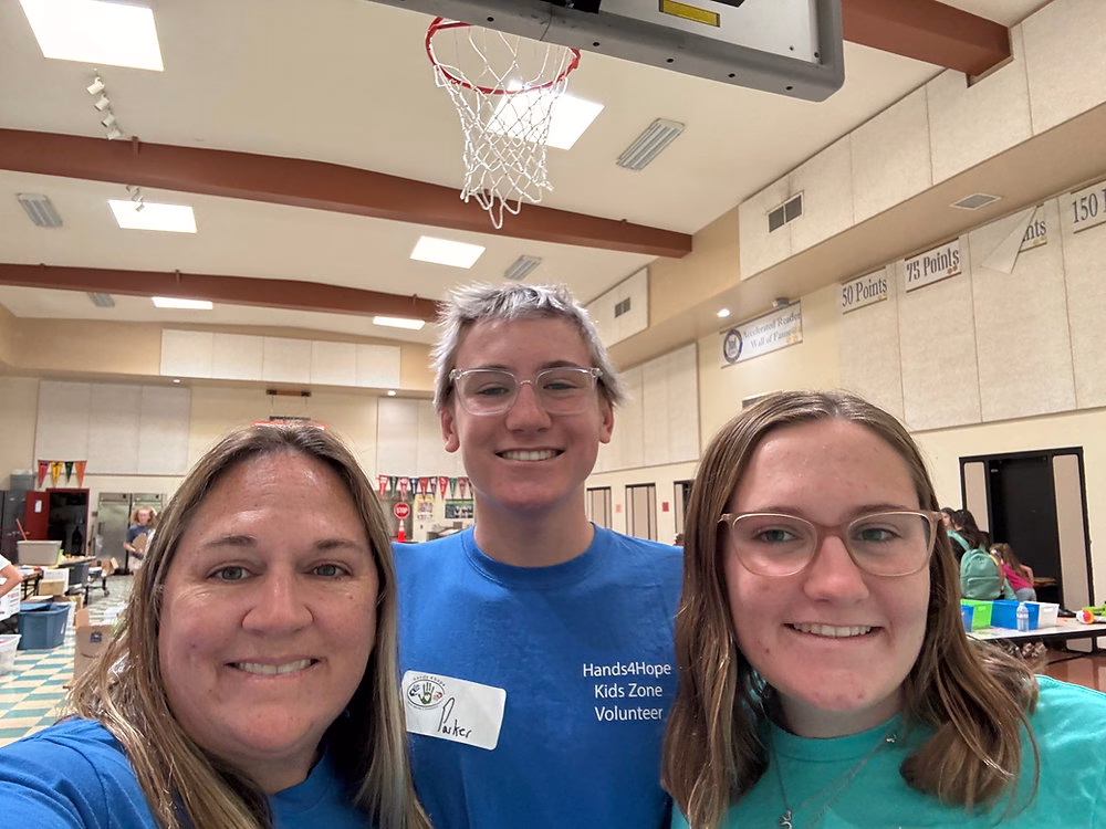 Three volunteers posing for a selfie at a community event