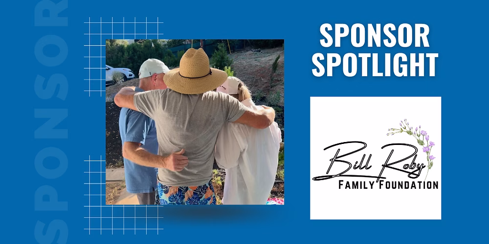 A man in a straw hat hugs a woman in a white shirt, while another man in a blue shirt looks on.