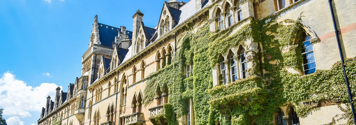 A historic building at Oxford University adorned with lush green ivy, showcasing the university's rich architectural heritage.